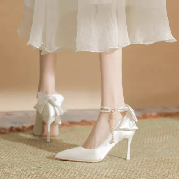 Giày cao gót nữ 9cm - mũi nhọn, chất liệu satin, đính ngọc trai & nơ, quai khóa, màu trắng, phù hợp cưới hỏi